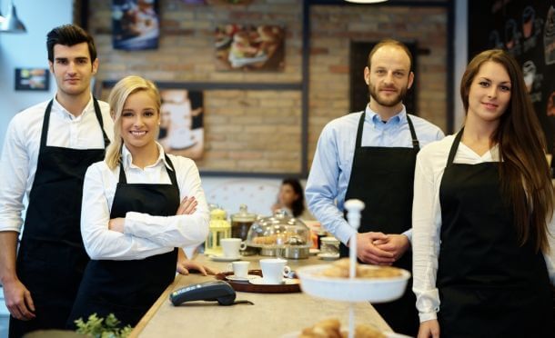 Brigade de cuisine or waiters posing in their restaurant