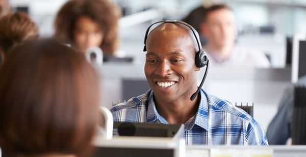 Call center agent sitting at his desk working with a smile