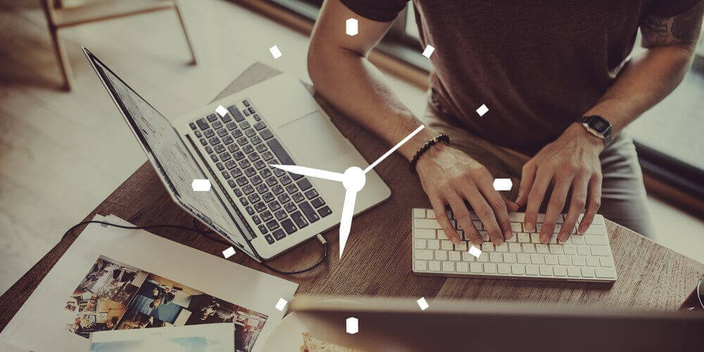 Man working on his macbook with a clock included as watermark to symbolize time